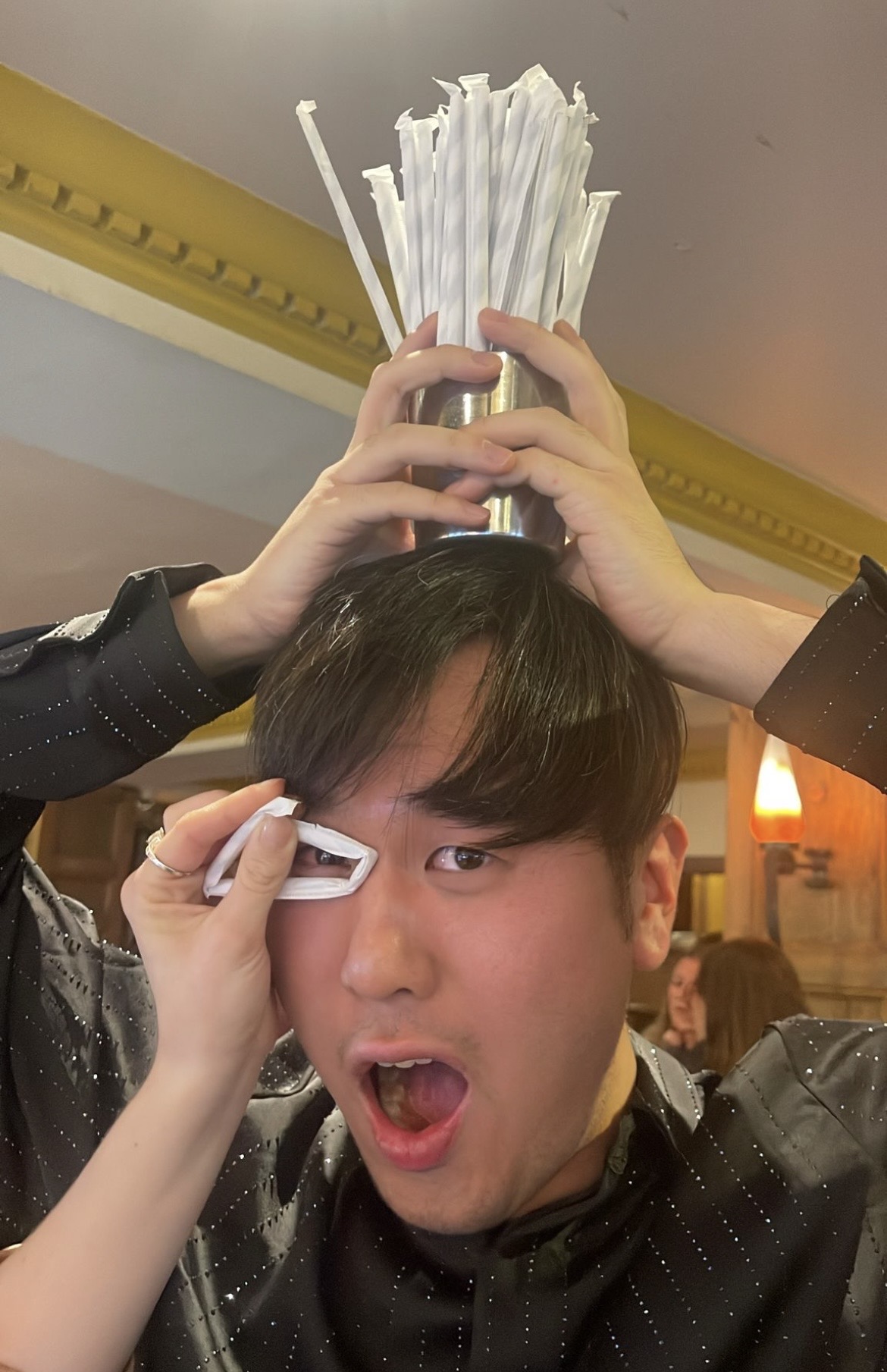 A teammate given a straw top hat and napkin monocle