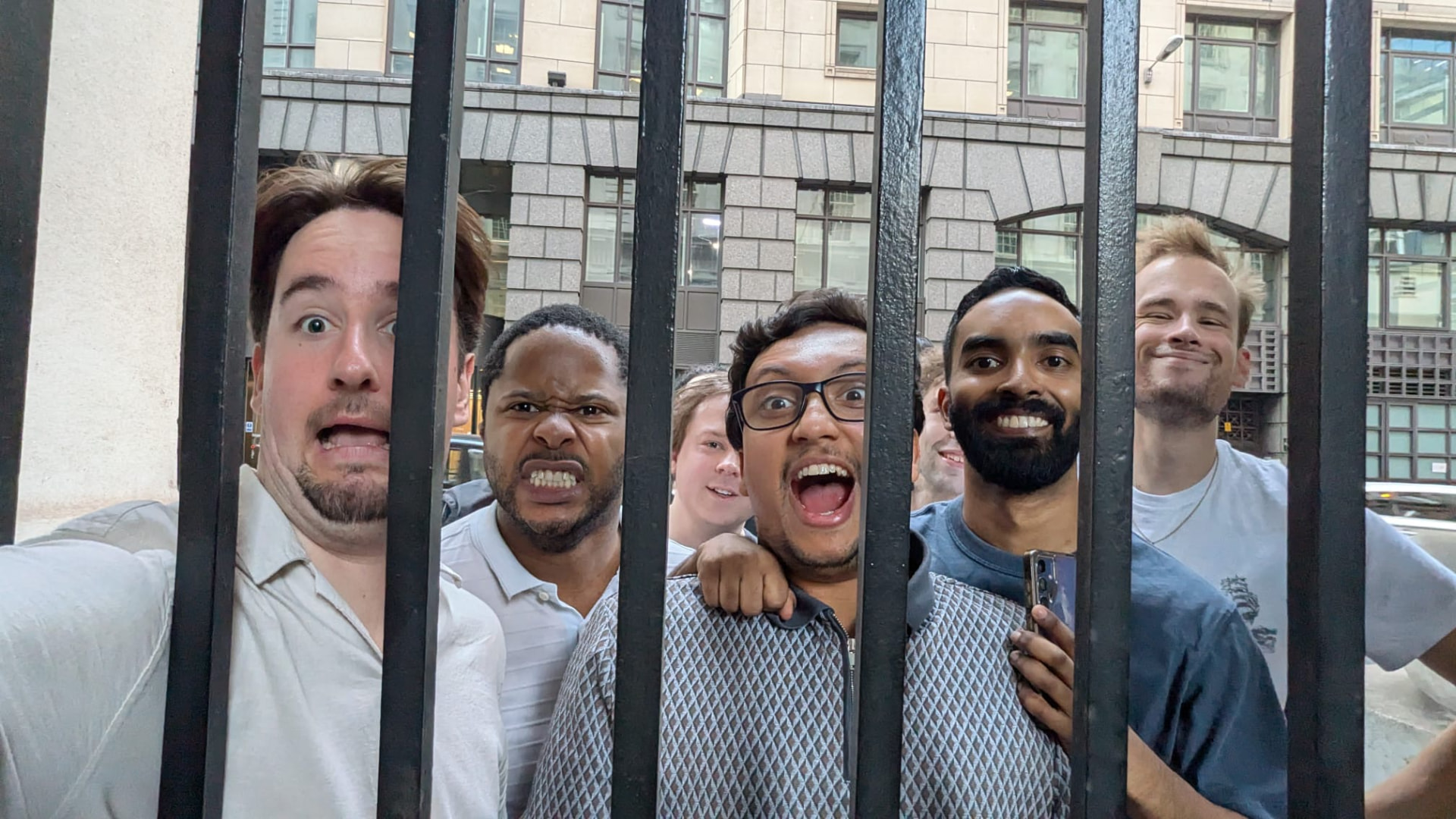 A team posing behind iron railings