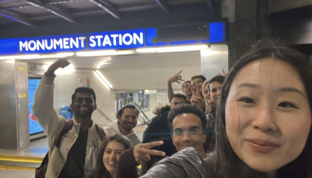 A team posing under a London station sign
